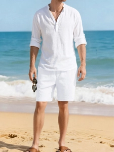 Close-up of white linen set featuring a Henley collar shirt and beach resort style texture
