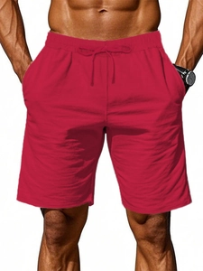 Detail shot of red men's sports shorts with elastic drawstring waist and side pockets