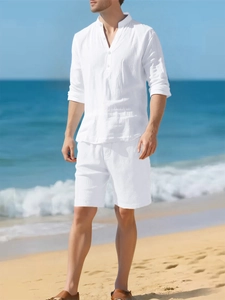 Close-up of white linen long sleeve shirt with henley collar and matching shorts on beach