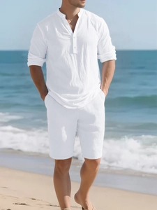 Linen beachwear set with white long sleeve henley shirt and shorts in a coastal setting