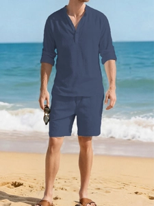 Close-up of men's navy blue linen set with long sleeve henley shirt on a sunny beach