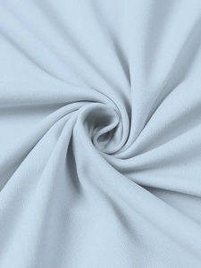 Macro detail of light blue ribbed knit fabric showing soft texture and premium drapery