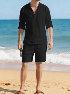 Detailed texture of men's black linen shirt and drawstring shorts on beach background