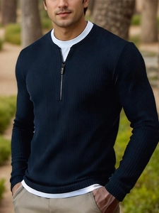 Detail of navy blue knit sweater featuring half-zip collar and layered white hem design