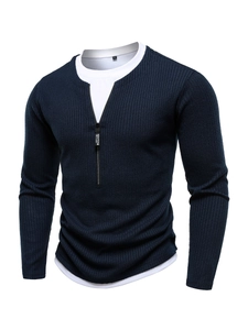 Detail of navy knit sweater showing ribbed texture and white layered hem design