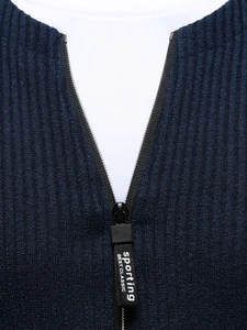 Close-up of ribbed knit sweater collar with black zipper and branded ribbon puller detail