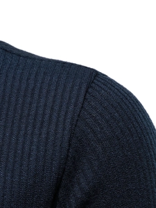 Detail view of the ribbed knit shoulder seam on a navy blue men's crewneck sweater