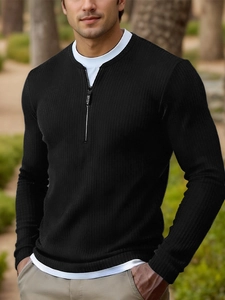 Detail of men's layered knit sweater with zipper collar and black ribbed fabric texture