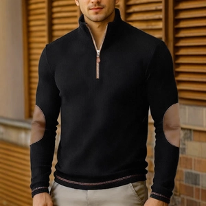 Close-up of black men's knit pullover featuring brown leather elbow patches and half-zip neck