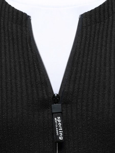 Detail of black ribbed knitwear neckline with sport-style zipper and layered white tee
