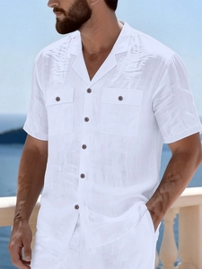 Close-up of white linen shirt showing textured fabric, Cuban collar and large double chest pockets