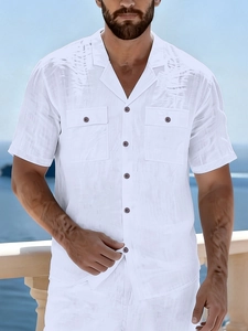 Detail of white linen shirt showing Cuban collar and dual breast pockets by the sea