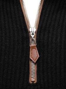 Detail of silver metal zipper with brown leather pull on black knitted sweatshirt