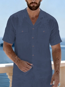 Detail of navy linen shirt with Cuban collar and dual chest pockets for beach leisure