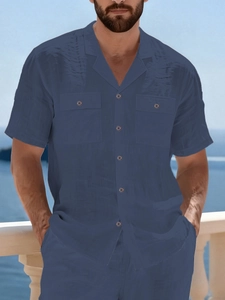 Detailed view of dark blue linen shirt with Cuban collar and dual chest pockets