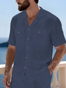 Detail of navy blue linen shirt showing the Cuban collar and textured front pockets