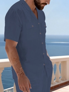 Detail of navy blue linen shirt with Cuban collar and dual chest pockets on balcony