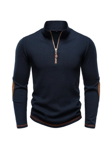 Detailed macro view of navy knit sweater showing quarter-zip collar and brown leather trim