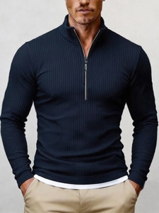 Detailed view of dark blue ribbed knit fabric and quarter-zip collar with sporting text