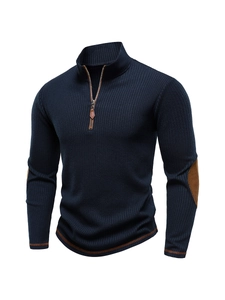 Detail of navy quarter-zip knit sweater with brown leather pull and elbow patches