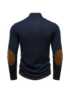 Detail of dark blue knit sweater showing brown faux suede elbow patches and ribbed texture