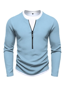 Detailed close-up of light blue waffle knit sweater featuring a metal half-zipper with logo
