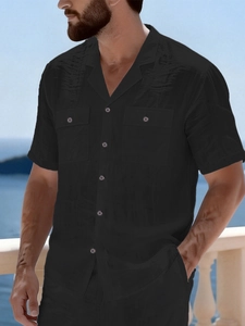 Close-up of black linen shirt showing Cuban collar and dual buttoned chest pockets