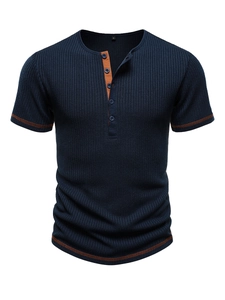 Detail of navy blue waffle knit Henley shirt featuring contrast orange stitching and buttons