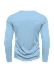 Detail view of light blue ribbed knit sweater with faux two-piece white layered hem design