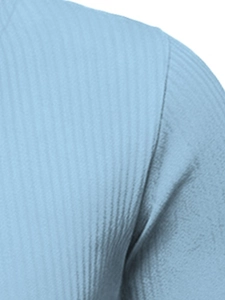 Macro shot of light blue knit fabric showing vertical ribbed texture and seam details