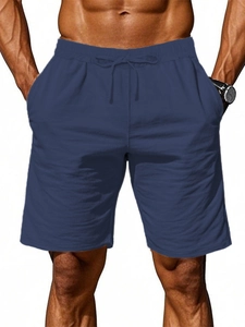 Detailed view of navy blue men's shorts showing elastic waistband and drawstring cords
