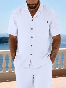 Detail of white linen shirt showing Cuban collar and dark wooden buttons in a resort setting