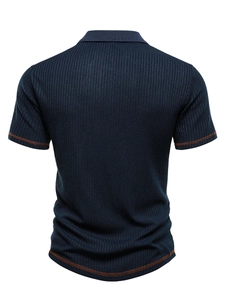 Detail view of navy ribbed fabric with orange contrast double stitching on men's polo