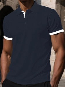 Detailed close-up of dark blue polo shirt with waffle texture and white contrast collar