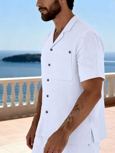 Close-up of white linen shirt featuring a Cuban collar and a functional chest pocket