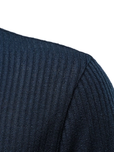 Close-up of the fine vertical ribbed knit texture on the dark blue polo shirt sleeve