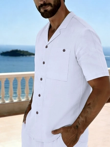 Close-up of white linen short sleeve shirt with Cuban collar and pocket in beach setting