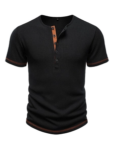 Detail of ribbed black Henley shirt featuring contrast orange stitching and button placket
