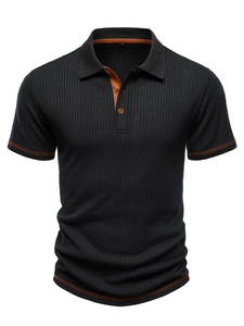 Detailed view of men's polo shirt featuring vertical knit texture and orange contrast stitching