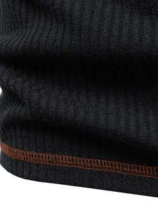 Macro detail of vertical ribbed knit fabric with contrasting orange overlock stitching