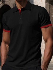Detail of black knit polo shirt with red trim placket and honeycomb texture