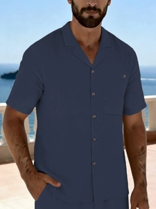 Detail of navy blue linen shirt with Cuban collar and chest pocket at beach resort