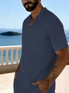 Detail of navy blue linen shirt with a classic camp collar and a buttoned chest pocket