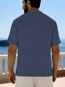 Back view of a men's loose linen short sleeve shirt in dark blue grey on beach