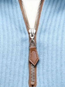 Detail of light blue ribbed knit sweater with brown zipper and leather pull tab