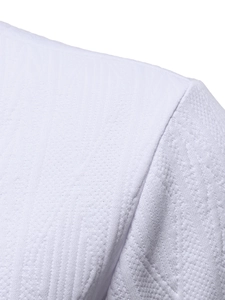 Macro detail of the high-quality white textured knit fabric on a men's polo shoulder