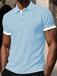 Detail of light blue waffle texture polo shirt featuring white contrast trim on sleeves