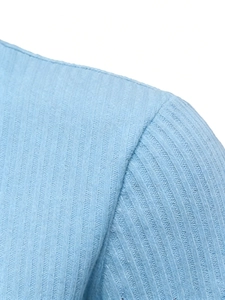 Close-up of light blue vertical ribbed knit fabric and precision shoulder seam details