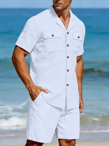 Close-up of white linen shirt detail featuring chest pockets and dark wooden buttons