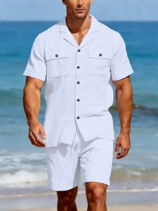 Detail of white linen set featuring short-sleeved shirt with chest pockets and drawstrings